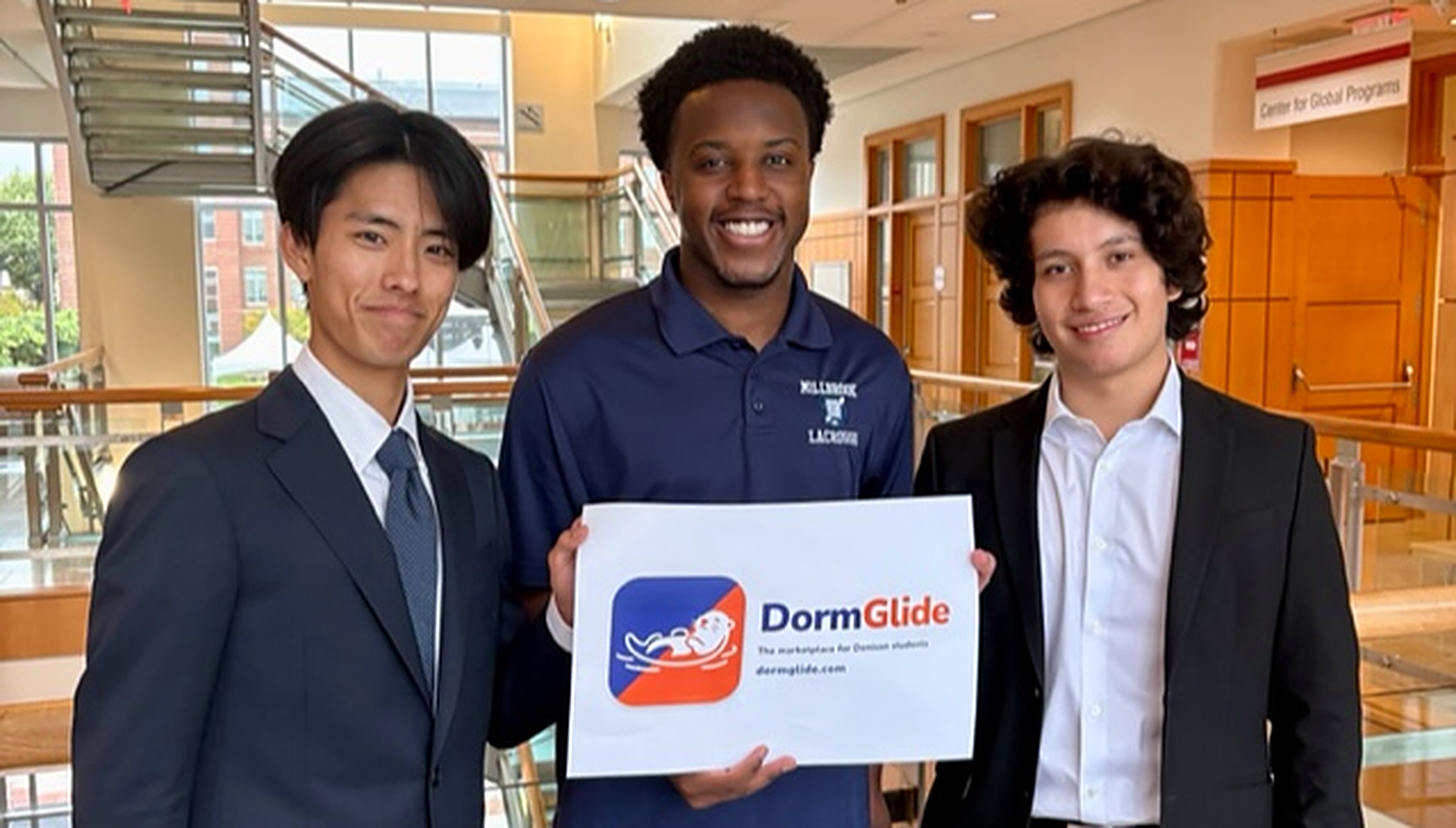 The DormGlide team holding the DormGlide sign